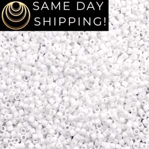 May include: A large collection of small, opaque white cylindrical beads scattered across the frame. A black rectangular banner at the top contains a gold circular logo and the white text SAME DAY SHIPPING! in a clean, sans-serif font.