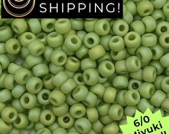 May include: Close-up of a pile of light green 6/0 Miyuki Round beads. The beads are small, cylindrical, and have a hole running through the center. The text "SAME DAY SHIPPING!" is in a black rectangle at the top.