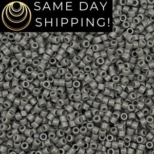 May include: A large collection of small, cylindrical, opaque grey beads with a smooth finish. The beads are uniform in shape and size, featuring a central hole for threading. The text SAME DAY SHIPPING is displayed in white on a black background.