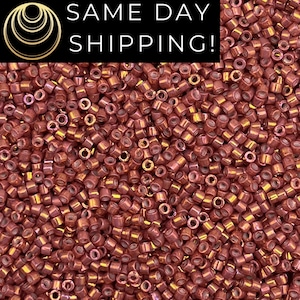 May include: A collection of small, cylindrical, metallic copper-colored beads with a reflective, iridescent finish. The beads are densely packed together, showing their hollow centers. A black banner at the top displays the text SAME DAY SHIPPING!