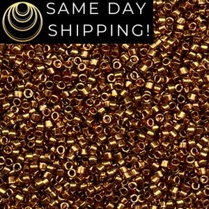 May include: Close-up of a pile of small, cylindrical, metallic gold beads. The beads are densely packed, creating a textured surface. The image includes the text "SAME DAY SHIPPING!" in a black rectangle.