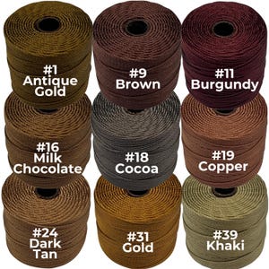 May include: Nine spools of cord in various colors, including Antique Gold, Brown, and Burgundy. Each spool is labeled with a number and color name. The colors range from light tan to dark brown and gold.