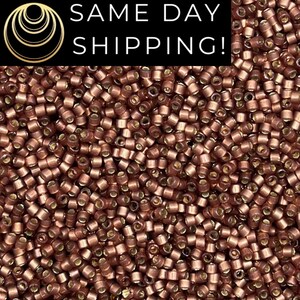 May include: Close-up of a pile of small, cylindrical copper-colored beads. The beads are densely packed, creating a textured surface. The image includes the text "SAME DAY SHIPPING!" in a black rectangle.
