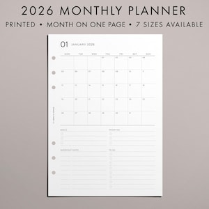 Peut inclure: Une page blanche d'un agenda mensuel 2026 avec une mise en page de calendrier pour janvier. La page comprend des sections pour les objectifs, les priorités et les listes de tâches. Le texte "2026 MONTHLY PLANNER" et "PRINTED • MONTH ON ONE PAGE • 7 SIZES AVAILABLE" est en haut.