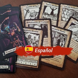 May include: A collection of game cards with illustrations of monsters and characters. The cards are in Spanish and feature titles like "Comida de Ogro" and "Reactivaci&oacute;n de Trampas".