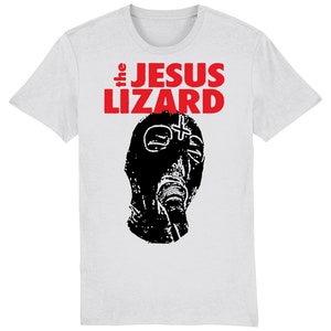 May include: White t-shirt featuring the band name "the JESUS LIZARD" in red block letters above a black graphic of a gas mask. The shirt is a crew neck style.