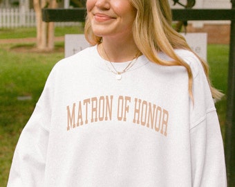 May include: A white sweatshirt with the text "MATRON OF HONOR" printed in brown on the front.