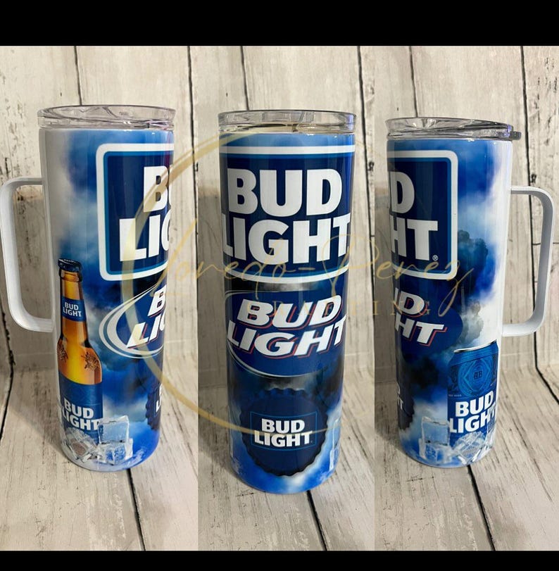 Pode incluir: Tr&ecirc;s canecas de a&ccedil;o inoxid&aacute;vel com tema Bud Light com al&ccedil;as brancas. As canecas apresentam o logotipo Bud Light em branco sobre um fundo azul com um design de nuvens. Uma caneca tem um gr&aacute;fico de garrafa Bud Light.