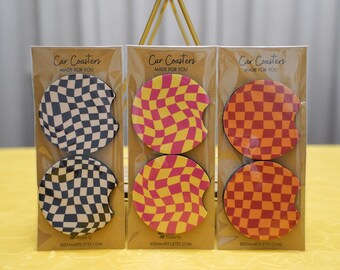 May include: Three sets of car coasters with a checkered pattern. The coasters are made of a thick, absorbent material and are designed to protect your car's cup holders from spills. The coasters are available in three color combinations: black and white, pink and yellow, and orange and red. The coasters are packaged in clear plastic bags and have a label that says "Car Coasters Made For You" and "Beemaarts Etsy.com".