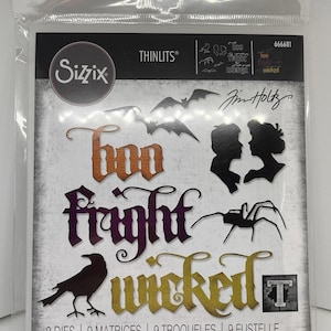 May include: A Sizzix Thinlits die set in a clear plastic package featuring nine metal cutting dies. The packaging displays the words Boo, Fright, and Wicked in stylized fonts, along with silhouettes of two people, a spider, a crow, and bats.