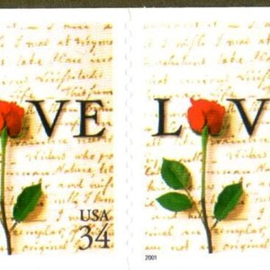 May include: Two vintage US postage stamps with a red rose and the word "LOVE" printed on each. The stamps are both dated 2001 and have a denomination of 34 cents.