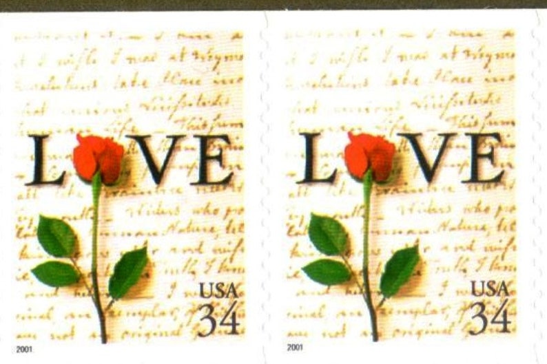 May include: Two vintage US postage stamps with a red rose and the word "LOVE" printed on each. The stamps are both dated 2001 and have a denomination of 34 cents.
