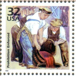 May include: A vintage-style illustration of two men pouring red liquid from a barrel. The stamp features the text "32 USA" and "Prohibition Enforced" with the year "1998" at the bottom.