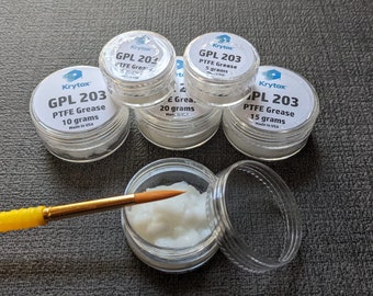May include: Five clear plastic containers of Krytox GPL 203 PTFE grease, with varying amounts of grease visible inside. The containers are labeled with the product name, size, and "Made in USA".