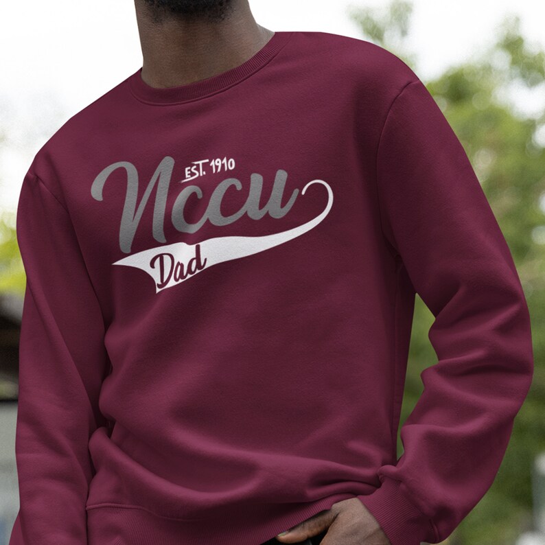May include: Burgundy sweatshirt with a white and grey graphic that says "NCCU EST. 1910" and "Dad" in a vintage style.