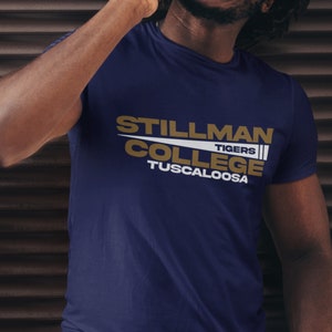 May include: A navy blue t-shirt with a gold and white graphic that reads "Stillman College Tigers Tuscaloosa".