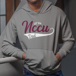 May include: Grey hooded sweatshirt with a white and maroon graphic that says "NCCU EST. 1910 Dad".