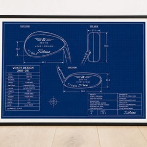 May include: A framed blueprint of a Titleist Vokey Design 260-06 golf wedge. The blue print includes top, side, and face views, with measurements in inches. The frame is black.