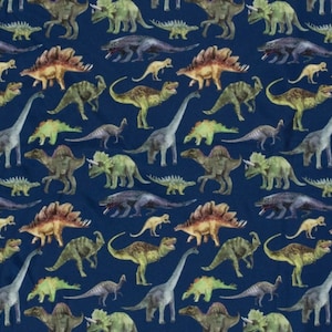 Könnte beinhalten: Ein blauer Stoff mit einem sich wiederholenden Muster aus bunten Dinosauriern. Die Dinosaurier sind in verschiedenen Posen und umfassen einen Stegosaurus, einen Triceratops, einen Brachiosaurus und andere.