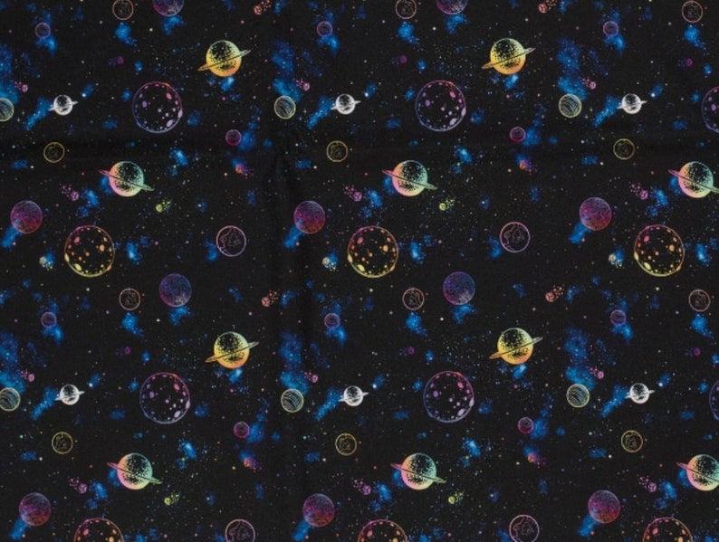 May include: A black fabric with a repeating pattern of planets and stars in rainbow colors. The planets have rings and are surrounded by a galaxy of stars.