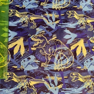 May include: A blue and yellow dinosaur skeleton pattern fabric with a repeating design of dinosaurs and footprints.