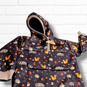 May include: A dark blue hooded sweatshirt with a pocket and a pattern of squirrels, hedgehogs, and birds on a white background.