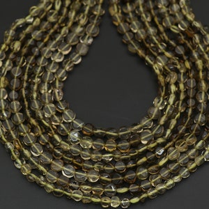 以下が含まれることがあります： 茶色と黄色の色合いの、半透明の丸いビーズの複数のストランド。ビーズは一緒にひもでつながれており、層状の効果を生み出しています。ビーズは磨かれた外観で、均一なサイズです。