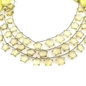 Puede incluir: Una hebra de cuentas de piedra preciosa de color amarillo claro en forma de estrella enhebradas en un alambre de plata.