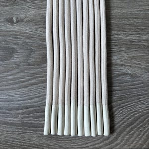 Op de afbeelding: Een bundel van tien witte veters met witte uiteinden.