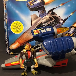 May include: A vintage Speed Peeler toy set. The set includes a blue and grey spaceship with orange flame details and a monkey-like action figure. The box art shows a similar spaceship with the text "Actual Firing Missile".