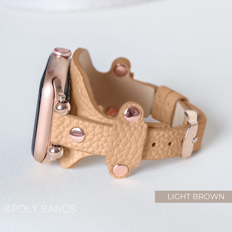 Puede incluir: Una correa de reloj de cuero marr&oacute;n claro con detalles y herrajes en oro rosa. La correa tiene un dise&ntilde;o &uacute;nico con una doble vuelta alrededor de la mu&ntilde;eca.