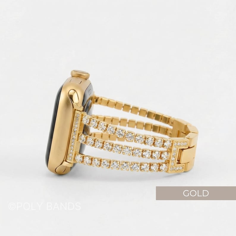 May include: A gold-colored smartwatch with a matching band. The band features three rows of sparkling, clear gemstones. The watch and band are set against a white background. The word "GOLD" is in a rectangular box.
