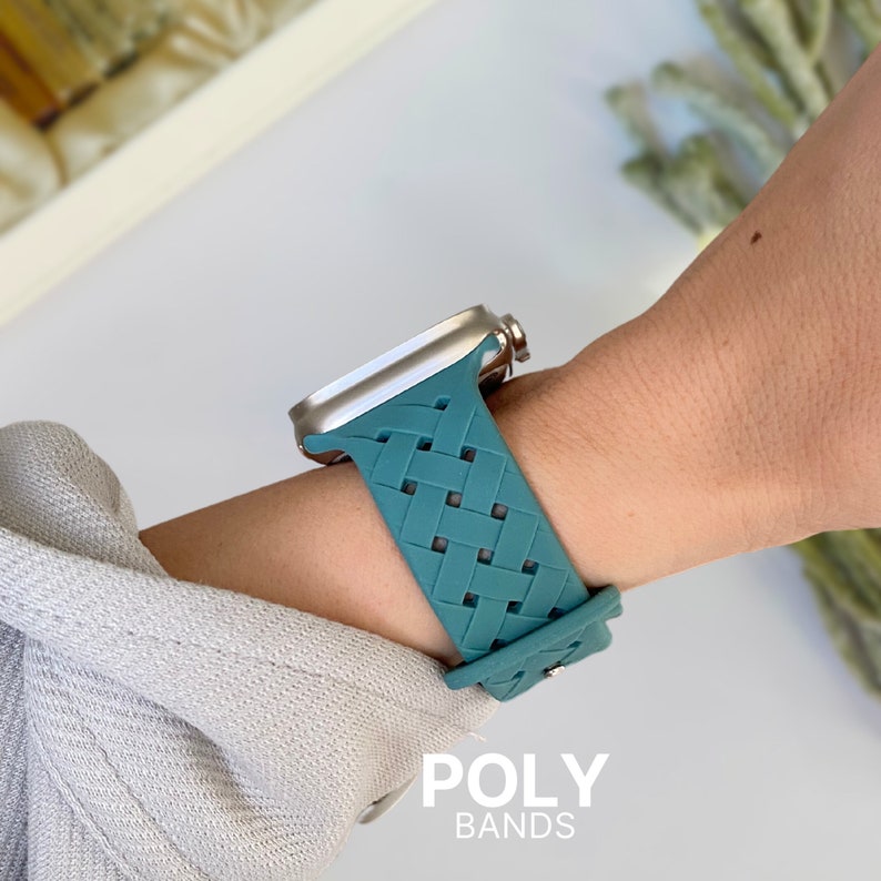 May include: Teal braided silicone watch strap for an Apple Watch. The strap has a woven pattern and is compatible with 40mm and 44mm Apple Watches. The strap is shown on a person's wrist. POLY BANDS is printed below the watch.