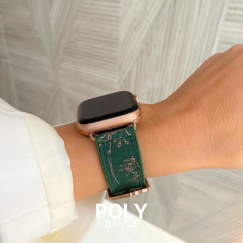 Op de afbeelding: Een groen en ros&eacute;goud Apple Watch bandje met een bloemenpatroon. Het bandje is gemaakt door POLY BANDS.