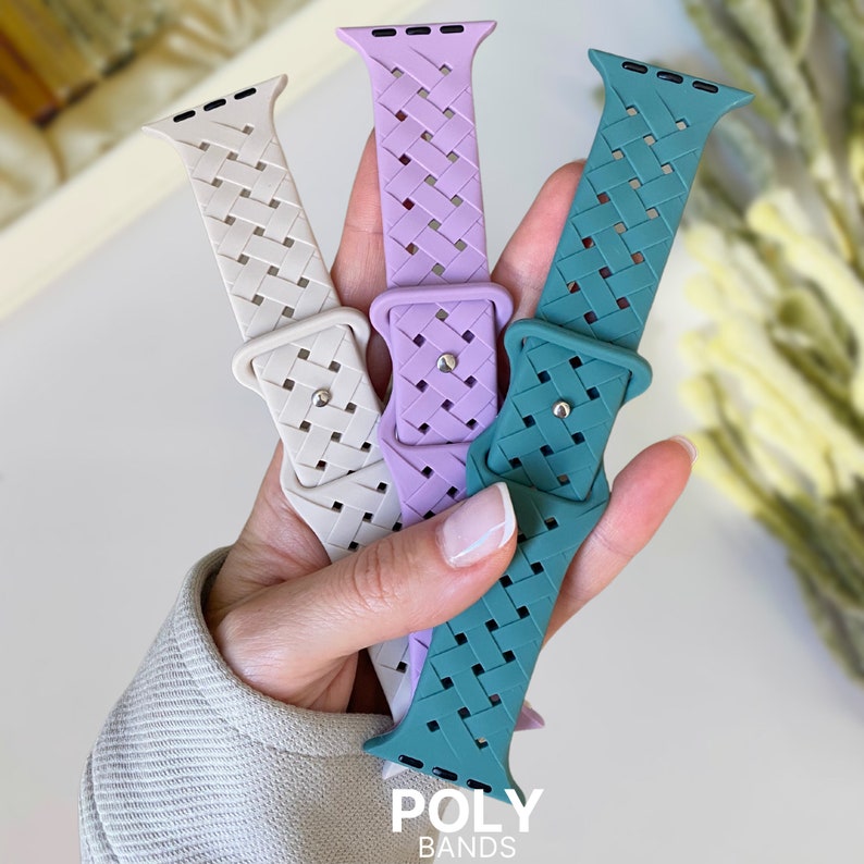 May include: Three braided Apple Watch bands in different colours: light beige, lavender, and teal. The bands are made of a woven material and have a textured finish. The text "POLY BANDS" is visible at the bottom of the image.