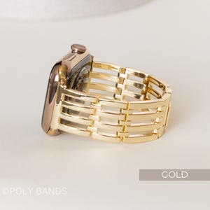 May include: A gold-colored Apple Watch with a matching gold band. The band features a woven design with horizontal and vertical bars. The word "GOLD" is in a rectangular box in the lower right corner. The text "&copy;POLY BANDS" is in the lower left corner.