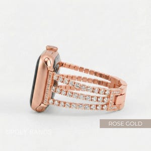 May include: Rose gold Apple Watch with a three-row rhinestone band. The watch face is black. The band is made of rose gold metal links and features three rows of clear rhinestones. The text "ROSE GOLD" is in the bottom right corner.