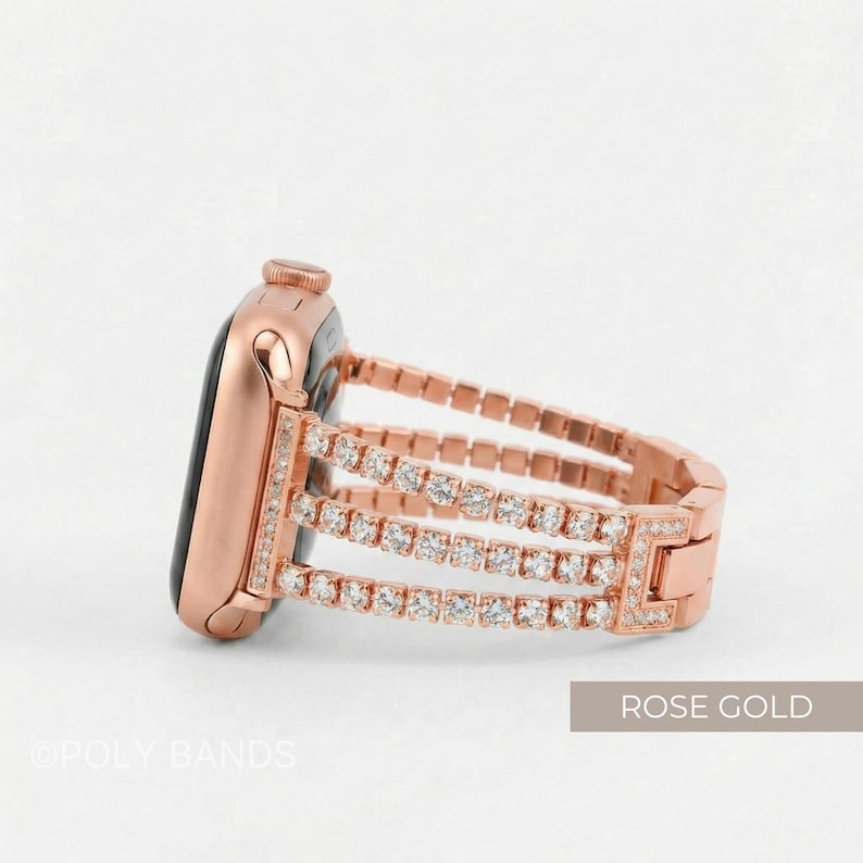 May include: Rose gold Apple Watch with a three-row rhinestone band. The watch face is black. The band is made of rose gold metal links and features three rows of clear rhinestones. The text "ROSE GOLD" is in the bottom right corner.