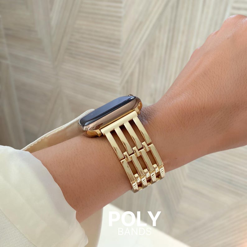 May include: A gold-colored watch band with a rectangular link design is shown on a wrist. The watch face is black with a gold-colored frame. The text "POLY BANDS" is visible at the bottom of the image.