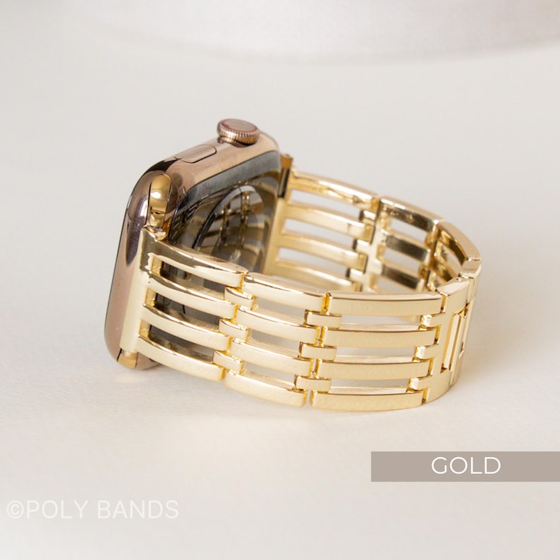 May include: A gold-colored Apple Watch with a matching gold band. The band features a woven design with rectangular links. The watch is displayed on a white surface. The word "GOLD" is printed on the bottom right corner.