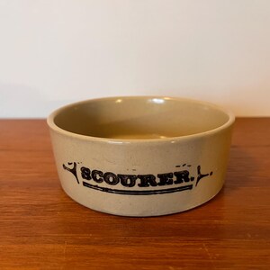 以下が含まれることがあります： ベージュのセラミックボウルに、黒い文字で「SCOURER.」と書いてあります