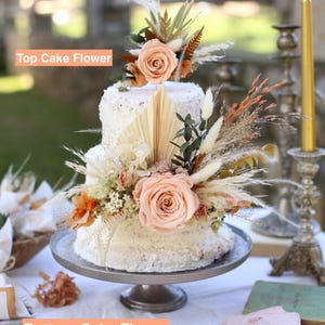 Wedding cake flower set featuring preserved blush roses, pampas grass, dried greenery and palm leaves. Includes top and bottom floral arrangements. Boho rustic handmade decor by GulFloraWedding.