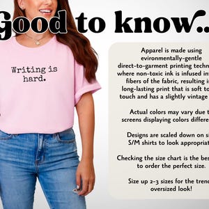 May include: A pale pink t-shirt with the words "Writing is hard" printed in black. The model is wearing blue jeans. The image also contains text about the apparel's printing and sizing information.