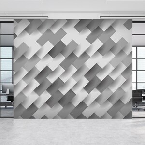 May include: A modern office interior with a wall covered in a geometric pattern of overlapping gray and white rectangles. The wall is a feature wall in a modern office space.
