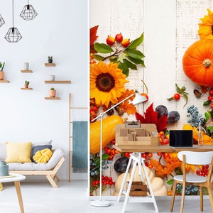 May include: A white wood background with fall decor, including pumpkins, gourds, sunflowers, berries, and leaves. A laptop computer and a white chair are in the foreground.