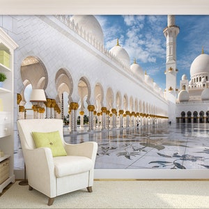 May include: A white mosque with intricate arches and a large courtyard. The mosque is decorated with gold accents and has a tall minaret.