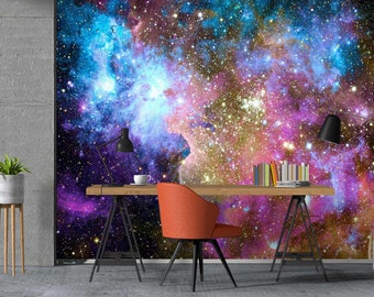 May include: A home office desk with a galaxy-themed wallpaper. The desk has a wooden top and black metal legs. A red chair is positioned in front of the desk. A potted plant is on a stand to the left of the desk.