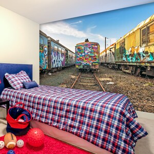Könnte beinhalten: Ein Schlafzimmer mit einer blauen und roten karierten Bettdecke und einem Wandbild von mit Graffiti besprühten Güterwagen. Das Wandbild zeigt einen Güterwagen mit einem bunten Farbmuster und den Worten "Peace" und "Love" an der Seite.