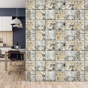 Puede incluir: Una pared de azulejos de cerámica decorativos con una variedad de patrones geométricos en tonos beige, marrón y gris. Los azulejos están dispuestos en un patrón aleatorio, creando un diseño único e interesante.