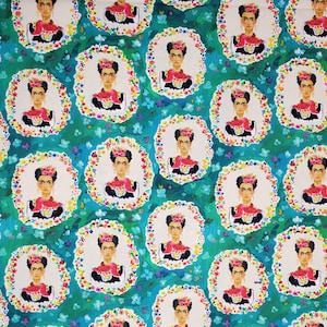 May include: A teal blue fabric with a repeating pattern of Frida Kahlo's portrait. Each portrait is surrounded by a wreath of colorful flowers.